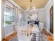 Bright dining room with large windows features a farmhouse table, elegant lighting, and hardwood floors for Gathering gatherings at 1209 Gunnison Ave, Orlando, FL 32804