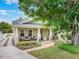 Inviting single-story home featuring a lovely front porch, lush lawn and paved driveway at 1209 Gunnison Ave, Orlando, FL 32804