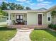 Charming home features a brick front porch, rocking chairs, and lush landscaping at 1209 Gunnison Ave, Orlando, FL 32804