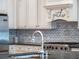 Close-up of updated kitchen with stainless steel appliances, subway tile backsplash, and bright lighting, perfect for cooking at 1209 Gunnison Ave, Orlando, FL 32804