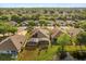 Aerial view of neighborhood showing backyard, screened in pool, and mature trees at 122 Lower Lake Ct, Debary, FL 32713