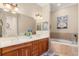 Spacious bathroom featuring double sinks, cherry cabinets, a garden tub, and tile surround at 122 Lower Lake Ct, Debary, FL 32713