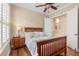 Bright bedroom features wood floors, ceiling fan, and ensuite bathroom at 122 Lower Lake Ct, Debary, FL 32713