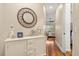 Hallway featuring wood floors, white dresser, and a decorative mirror on the wall at 122 Lower Lake Ct, Debary, FL 32713