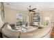 Cozy living room with a ceiling fan, hardwood floors, and a comfortable sectional sofa with a view to the lanai at 122 Lower Lake Ct, Debary, FL 32713