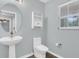 Small bathroom includes pedestal sink, wood laminate floors, and cabinet above toilet at 13118 Honey Locust Dr, Orlando, FL 32828