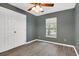 Bedroom has wood laminate flooring, a ceiling fan, a closet, and a window to let in natural light at 13118 Honey Locust Dr, Orlando, FL 32828