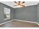 Bedroom featuring wood laminate floors, a ceiling fan, and a window with neighborhood views at 13118 Honey Locust Dr, Orlando, FL 32828