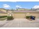 Exterior view of townhomes featuring a two-car garage and manicured bushes at 13118 Honey Locust Dr, Orlando, FL 32828