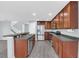Open kitchen featuring stainless steel appliances, dark countertops and cabinetry, and wood laminate flooring at 13118 Honey Locust Dr, Orlando, FL 32828