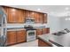 Close up of the kitchen with stainless steel stove, oven, microwave, wood cabinets, and dark countertops at 13118 Honey Locust Dr, Orlando, FL 32828