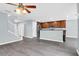 Modern living room with a kitchen and modern gray floors, ceiling fan, and breakfast bar at 13118 Honey Locust Dr, Orlando, FL 32828
