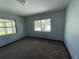 Comfortable bedroom featuring neutral walls, plush carpeting, ample natural light, and windows overlooking the outdoors at 1312 Simmons Rd, Kissimmee, FL 34744
