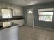 Functional kitchen featuring updated countertops, white cabinets, tile flooring, and a back door at 1312 Simmons Rd, Kissimmee, FL 34744