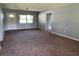 Cozy living room with neutral walls, plush carpeting, a front entry door, and plenty of natural light at 1312 Simmons Rd, Kissimmee, FL 34744