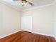 This bedroom features wooden floors, a ceiling fan, crown moulding and a closet with white paneled doors at 13139 Paloma Dr, Orlando, FL 32837