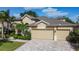 Lovely exterior view with a three-car garage, lush greenery, and a brick paved driveway at 13139 Paloma Dr, Orlando, FL 32837