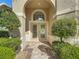 Elegant front entrance with double doors, an arched transom window, and meticulously maintained greenery at 13139 Paloma Dr, Orlando, FL 32837