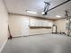 Three car garage featuring epoxy flooring, overhead storage, and convenient access door at 13139 Paloma Dr, Orlando, FL 32837
