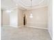 A large living room with tile floors, detailed trim, and a chandelier opens into another room at 13139 Paloma Dr, Orlando, FL 32837