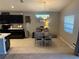 Dining area with wood table, seating for four, bright natural light, and modern hanging light fixture at 1381 Woodlark Dr, Haines City, FL 33844