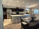 Modern kitchen featuring dark cabinetry, stainless steel appliances, and a large island with seating at 1381 Woodlark Dr, Haines City, FL 33844