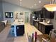 Spacious kitchen with an island featuring stone countertops, dark cabinetry and stainless appliances at 1381 Woodlark Dr, Haines City, FL 33844