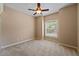 Bedroom features neutral carpet, ceiling fan, and window overlooking the landscape at 1544 Hunters Mill Pl, Oviedo, FL 32765