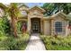 Inviting home entrance with a stone archway, double doors, and lush landscaping along the walkway at 1544 Hunters Mill Pl, Oviedo, FL 32765