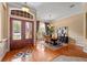 Inviting foyer showcases hardwood floors, decorative glass doors, and a dining area with elegant furnishings at 1544 Hunters Mill Pl, Oviedo, FL 32765