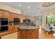 Open kitchen boasts wood cabinetry, granite counters, stainless appliances and center island at 1544 Hunters Mill Pl, Oviedo, FL 32765