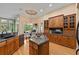 Gourmet kitchen features a center island, wooden cabinets and view to outdoor patio at 1544 Hunters Mill Pl, Oviedo, FL 32765