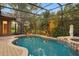 Beautiful pool with lush landscaping and a screened enclosure at 1544 Hunters Mill Pl, Oviedo, FL 32765