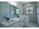 Modern bathroom with dual vanity, quartz counters, and a tiled walk-in shower at 160 Fisher Loop, Ocklawaha, FL 32179
