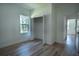 Bright bedroom with wood-look flooring, closet, and a window with outdoor view at 160 Fisher Loop, Ocklawaha, FL 32179