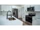 Close up of Kitchen featuring white cabinets, stainless steel appliances, and black fixtures at 160 Fisher Loop, Ocklawaha, FL 32179