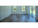 Bright living room features wood-look flooring and sliding glass doors to the patio at 160 Fisher Loop, Ocklawaha, FL 32179