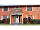 Charming two-story condo featuring a welcoming entrance with decorative landscaping and white trim at 1651 W Oak Ridge Rd # 1651A, Orlando, FL 32809