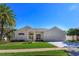 Charming one-story home featuring a two-car garage, well-manicured lawn and palm trees at 1701 Knotting Hill Dr, Orlando, FL 32835