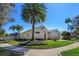 A charming home with a well-maintained lawn, mature palm trees, and a two-car garage at 1701 Knotting Hill Dr, Orlando, FL 32835