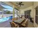 Inviting covered patio with ceiling fan, dining set, and access to a screened-in pool area at 1701 Knotting Hill Dr, Orlando, FL 32835