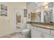 Bathroom featuring granite counters, white cabinetry, large mirror, and glass door to outside at 1723 Lee Janzen Dr, Kissimmee, FL 34744