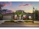 Charming home with lush landscaping, palm trees, and a well-maintained lawn at sunset at 1723 Lee Janzen Dr, Kissimmee, FL 34744