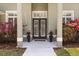 Inviting front entrance with double doors framed by columns and vibrant landscaping at 1723 Lee Janzen Dr, Kissimmee, FL 34744