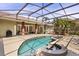 Screened in pool and jacuzzi surrounded by a patio area and tropical landscaping at 1723 Lee Janzen Dr, Kissimmee, FL 34744