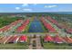 Expansive aerial view of a community featuring vibrant red tile roofs and a central lake at 2335 Symphony Cir, St Cloud, FL 34771