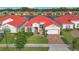 Aerial view of a beautiful home with a red tile roof in a lakeside community at 2335 Symphony Cir, St Cloud, FL 34771