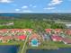 Aerial of community pool, clubhouse and surrounding homes with mature trees and a lake in the background at 2335 Symphony Cir, St Cloud, FL 34771