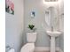 Bathroom with neutral colors, pedestal sink, oval mirror, and a plant on the toilet at 2335 Symphony Cir, St Cloud, FL 34771