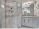 Sleek bathroom with glass shower, hand shower head, gray and white mosaic tiles, and granite countertops at 2335 Symphony Cir, St Cloud, FL 34771